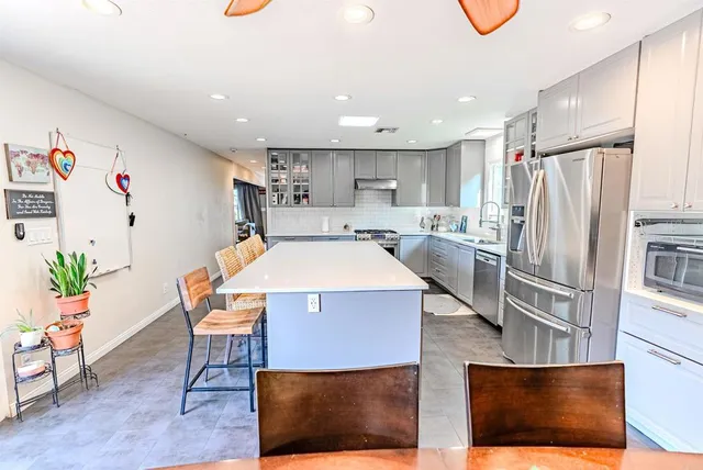 a kitchen with a table chairs refrigerator and microwave