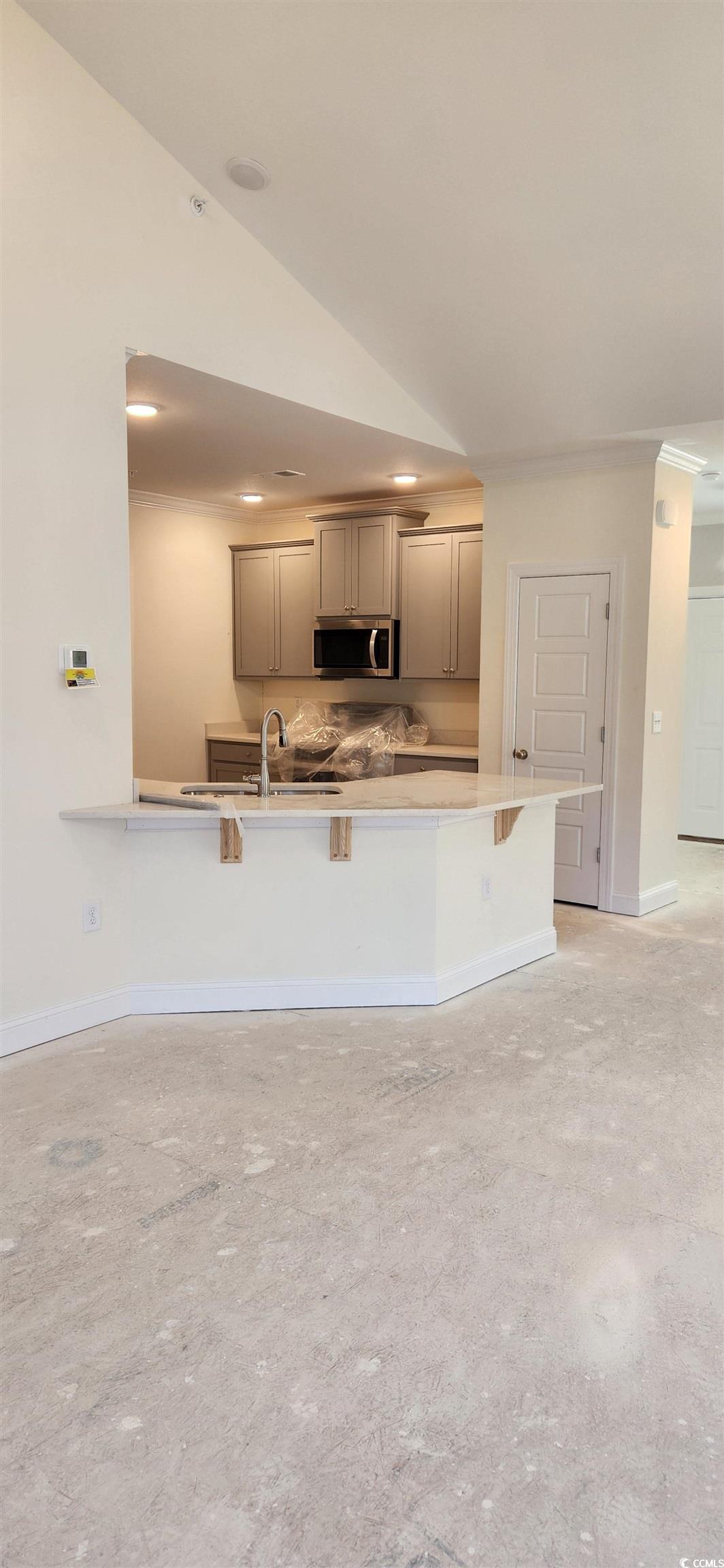1147 Freeboard Street, Unit 201 Murrells Inlet, SC 29576 - Photo 28 of 38 Kitchen with a kitchen breakfast bar, kitchen peninsula, and vaulted ceiling
