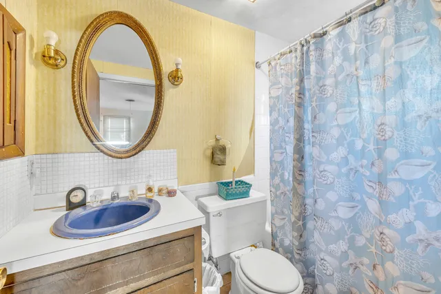 a bathroom with a sink a mirror a toilet and a sink