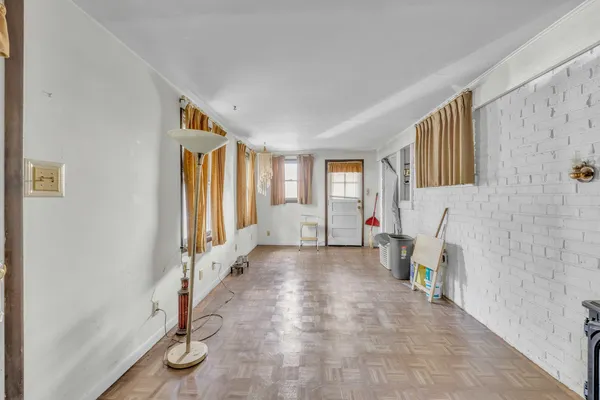 a view of an empty room with a fireplace and a window