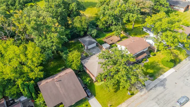 an aerial view of a house with a yard and trees