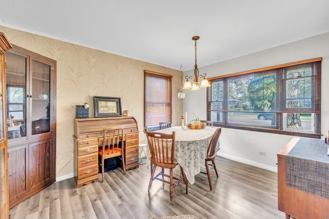 a dining room with furniture a chandelier and wooden floor