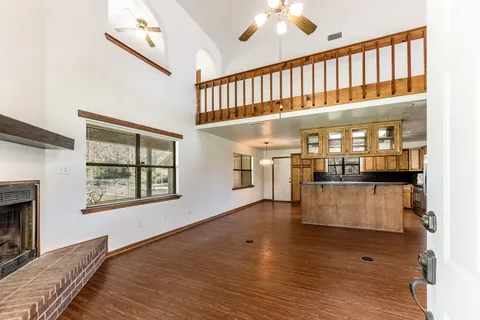 a hallway with wooden floor and staircase