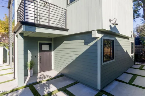 a kitchen with stainless steel appliances kitchen island granite countertop a refrigerator oven a sink dishwasher a dining table and chairs with wooden floor