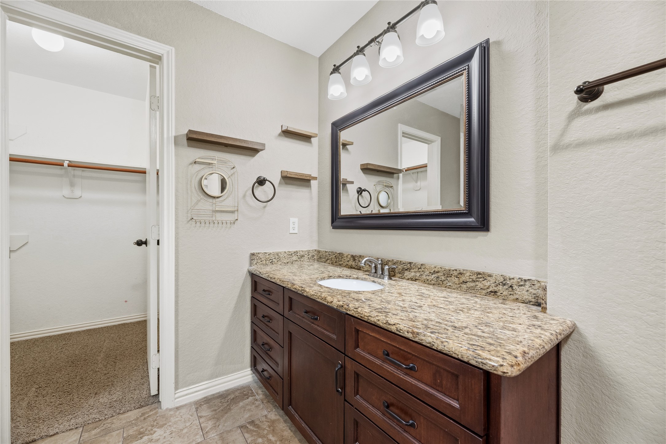 24006 Lazy Kay Lane Hockley, TX 77447 - Photo 12 of 21 This bathroom features granite countertops and dark wood cabinetry.