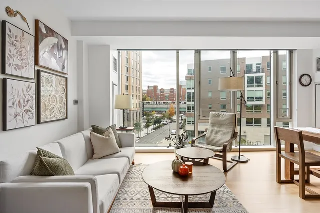 a living room with furniture a flat screen tv and kitchen view