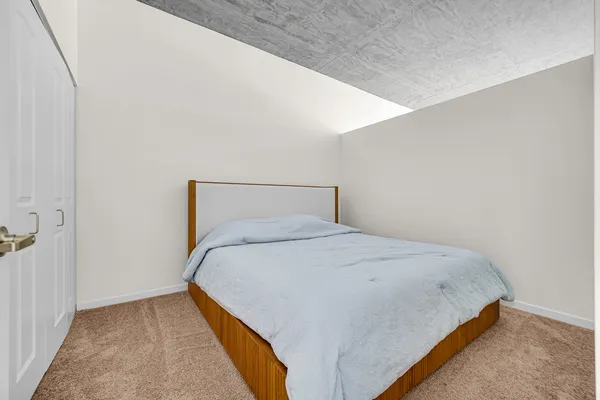 a bedroom with a bed and a large window