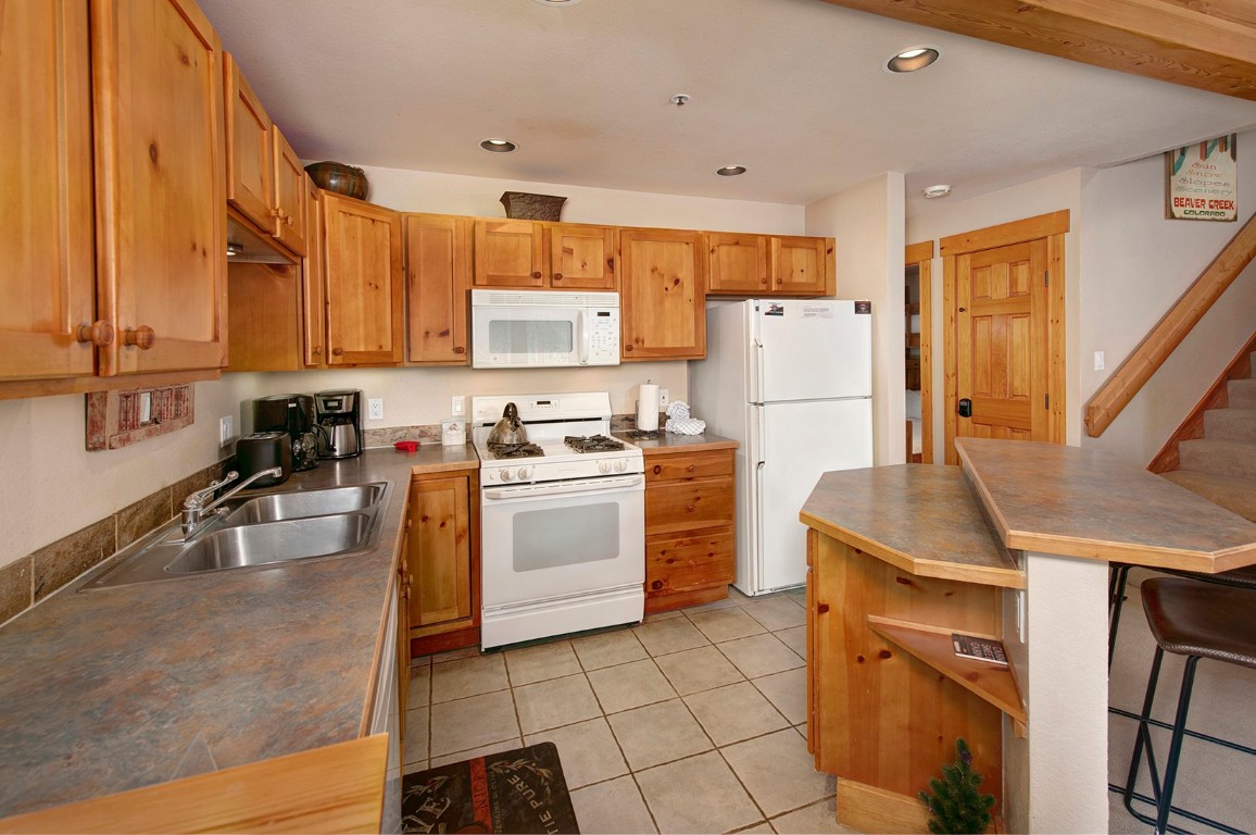 28 Trappers Crossing Trail, Unit 8760 Keystone, CO 80435 - Photo 11 of 37 a kitchen with a sink a stove and refrigerator