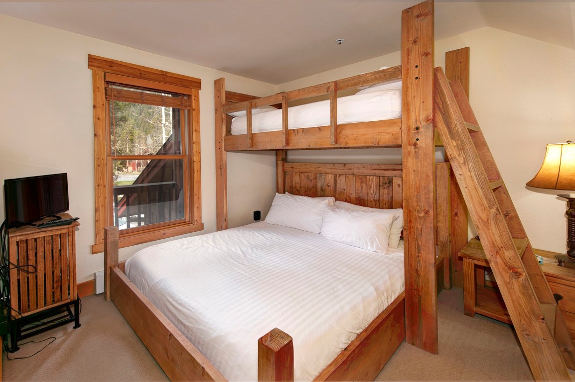 28 Trappers Crossing Trail, Unit 8760 Keystone, CO 80435 - Photo 17 of 37 a bedroom with a large bed and a flat tv screen on dresser