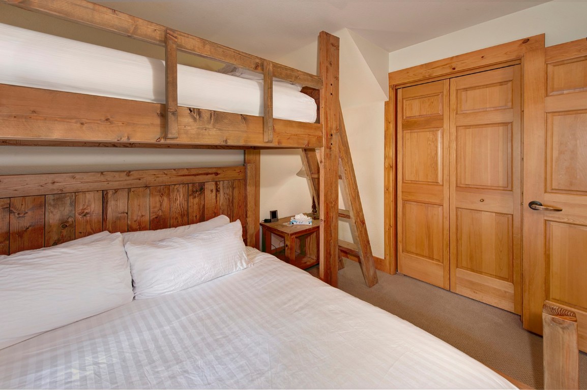 28 Trappers Crossing Trail, Unit 8760 Keystone, CO 80435 - Photo 18 of 37 a bedroom with a bed and a table