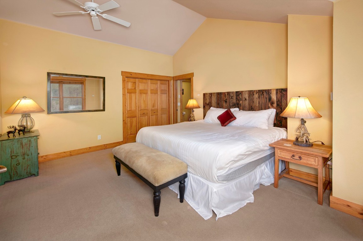 28 Trappers Crossing Trail, Unit 8760 Keystone, CO 80435 - Photo 20 of 37 a bedroom with a bed and lamp with table