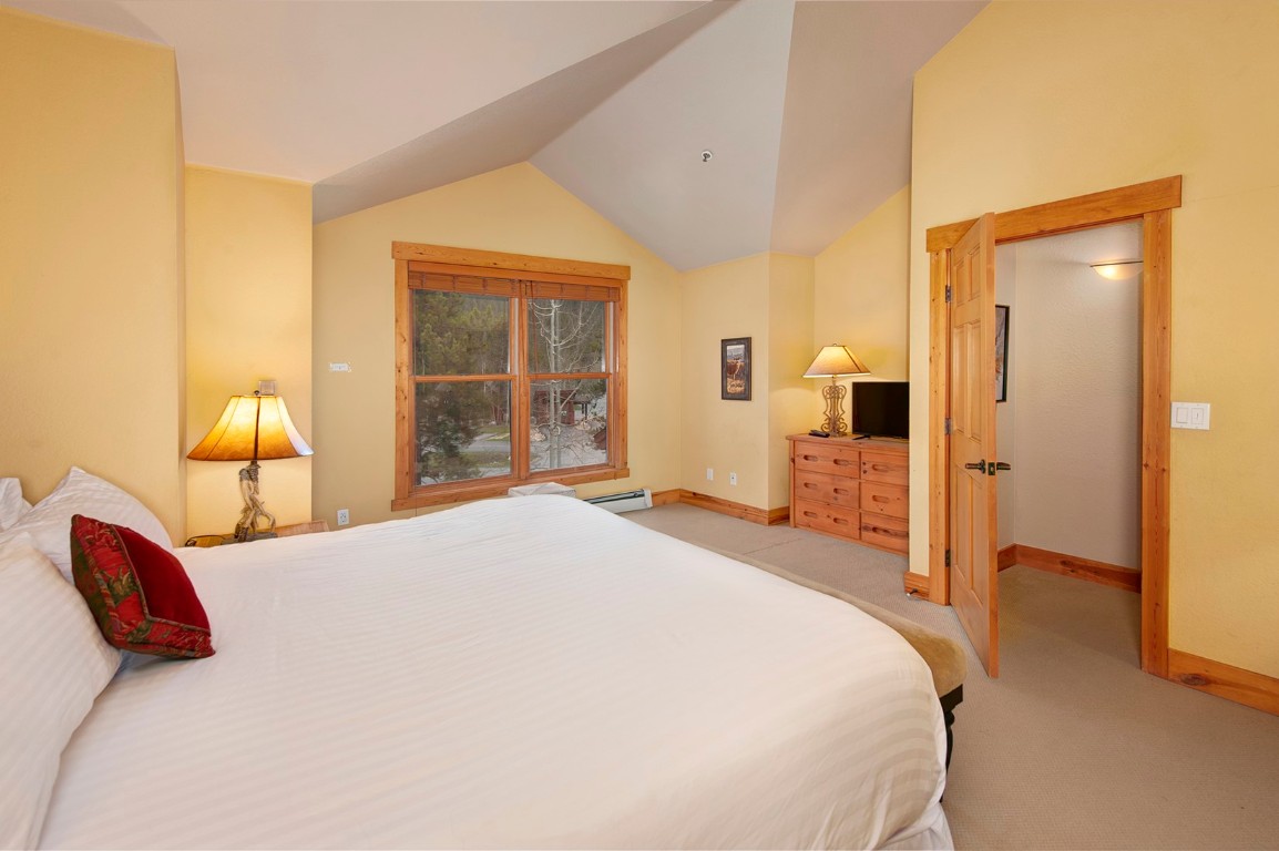 28 Trappers Crossing Trail, Unit 8760 Keystone, CO 80435 - Photo 21 of 37 a bedroom with a bed and wooden floor