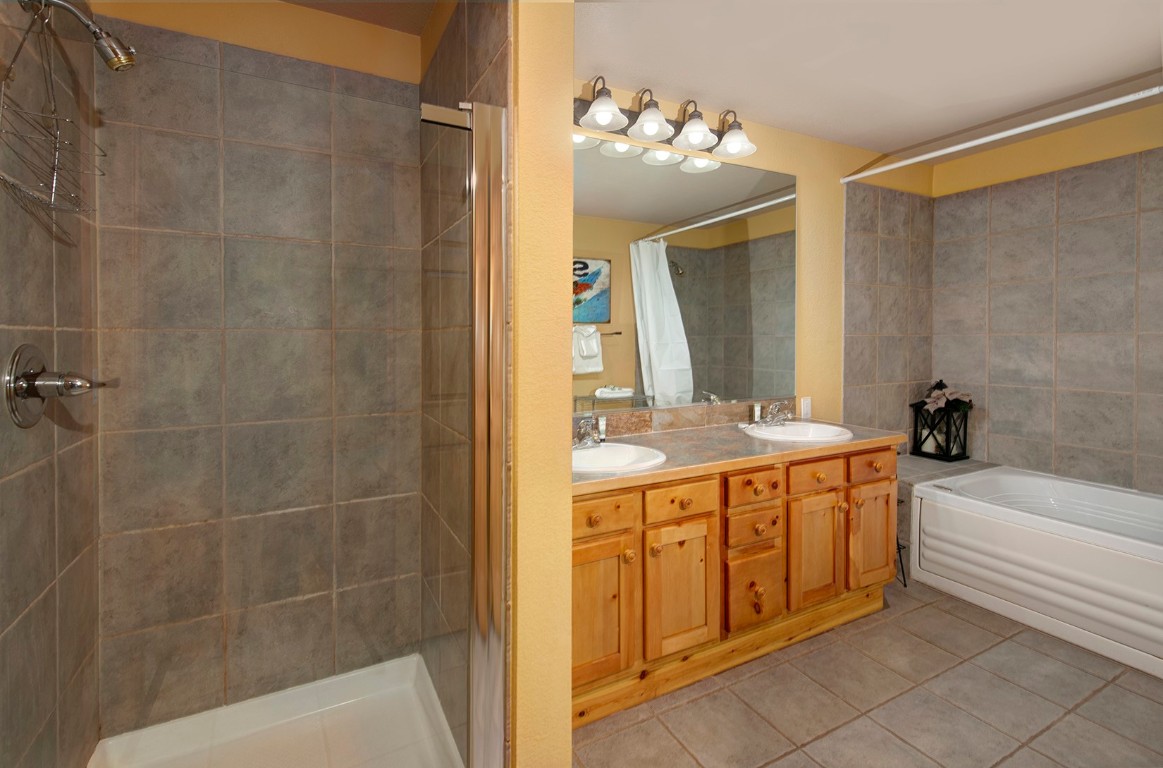 28 Trappers Crossing Trail, Unit 8760 Keystone, CO 80435 - Photo 23 of 37 a bathroom with a tub a sink and mirrors