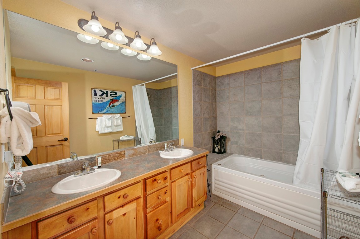 28 Trappers Crossing Trail, Unit 8760 Keystone, CO 80435 - Photo 24 of 37 a bathroom with a granite countertop sink a large mirror and a bathtub