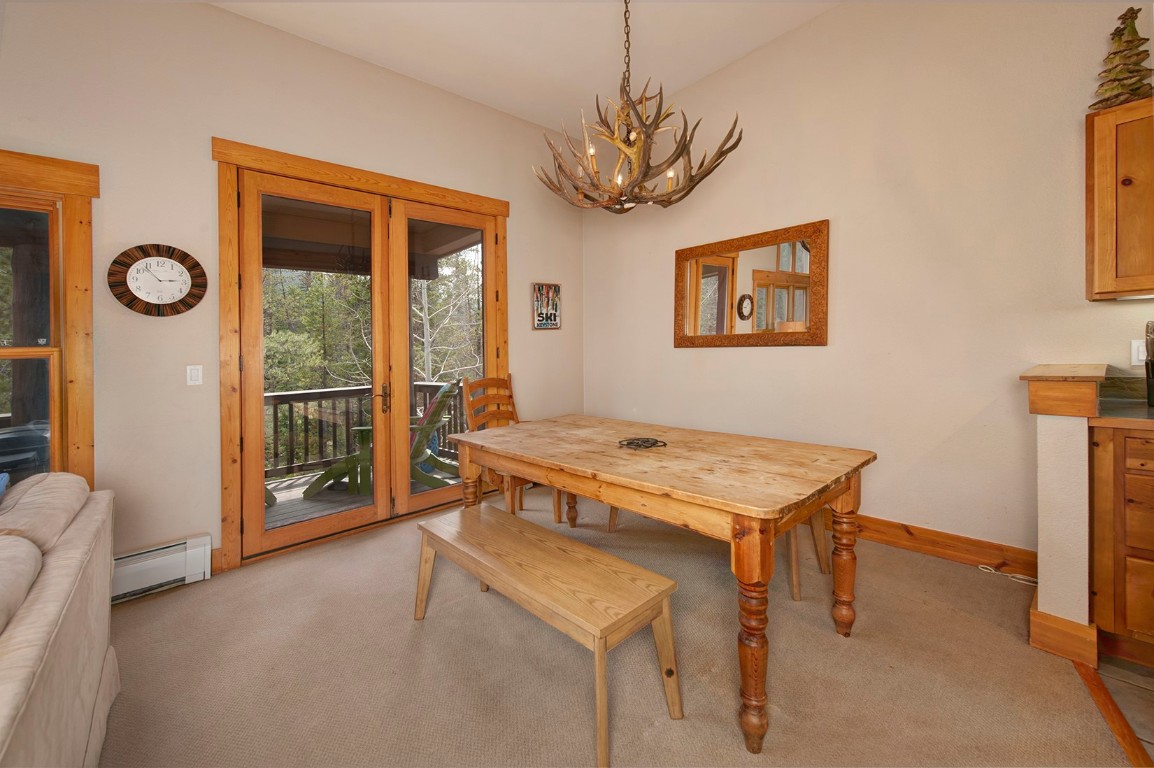 28 Trappers Crossing Trail, Unit 8760 Keystone, CO 80435 - Photo 8 of 37 a living room with a table chairs and a chandelier