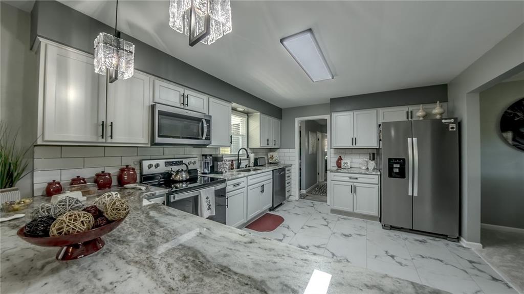 7 Indian Lane Vanderbilt, PA 15486 - Photo 24 of 38 a kitchen with stainless steel appliances kitchen island granite countertop a refrigerator stove and sink