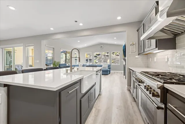 a large kitchen with stainless steel appliances granite countertop a lot of counter space and wooden floors