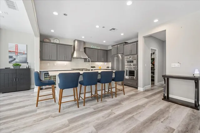 a kitchen with stainless steel appliances kitchen island granite countertop a refrigerator and cabinets