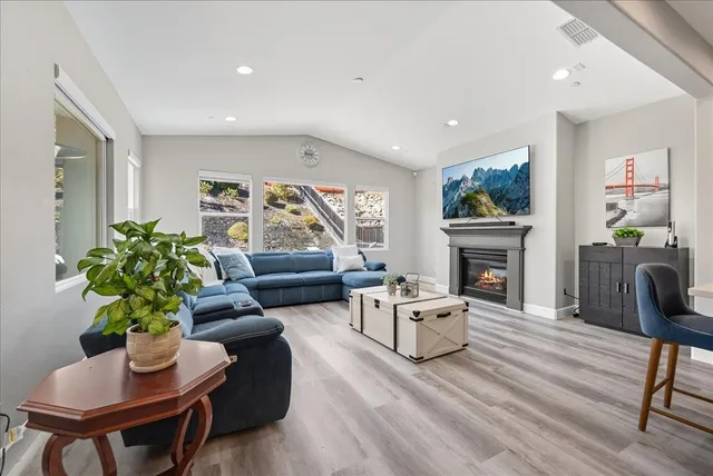 a living room with furniture a fireplace and a flat screen tv