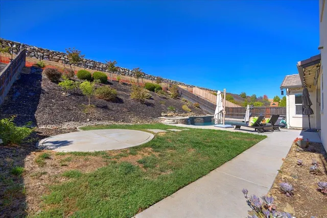 a view of a yard with table and chairs with wooden fence