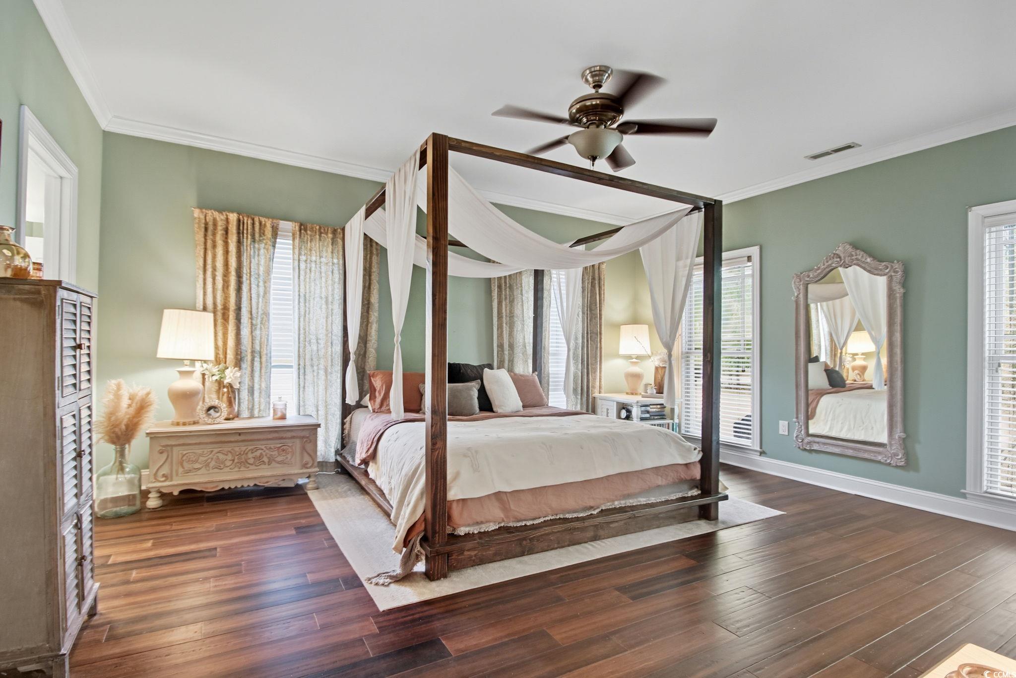 21 Craftsman Lane Georgetown, SC 29440 - Photo 22 of 39 Bedroom with multiple windows, crown molding, dark wood-style floors, and a ceiling fan