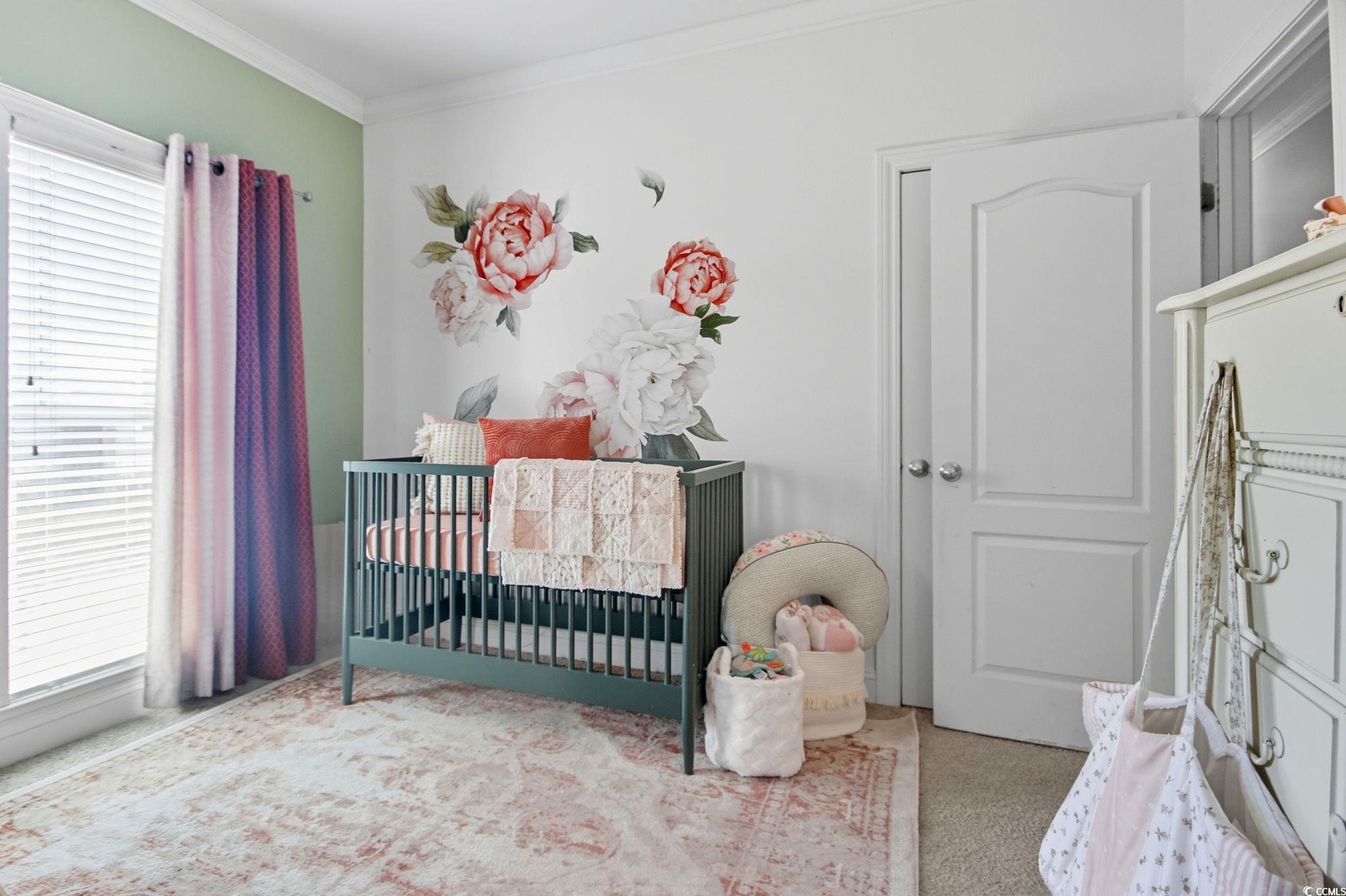 21 Craftsman Lane Georgetown, SC 29440 - Photo 27 of 39 Carpeted bedroom featuring a nursery area and crown molding