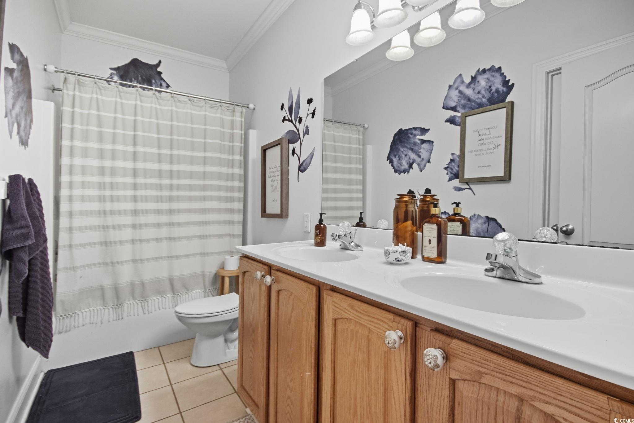21 Craftsman Lane Georgetown, SC 29440 - Photo 29 of 39 Full bathroom with shower / bathtub combination with curtain, light tile patterned flooring, double vanity, and crown molding