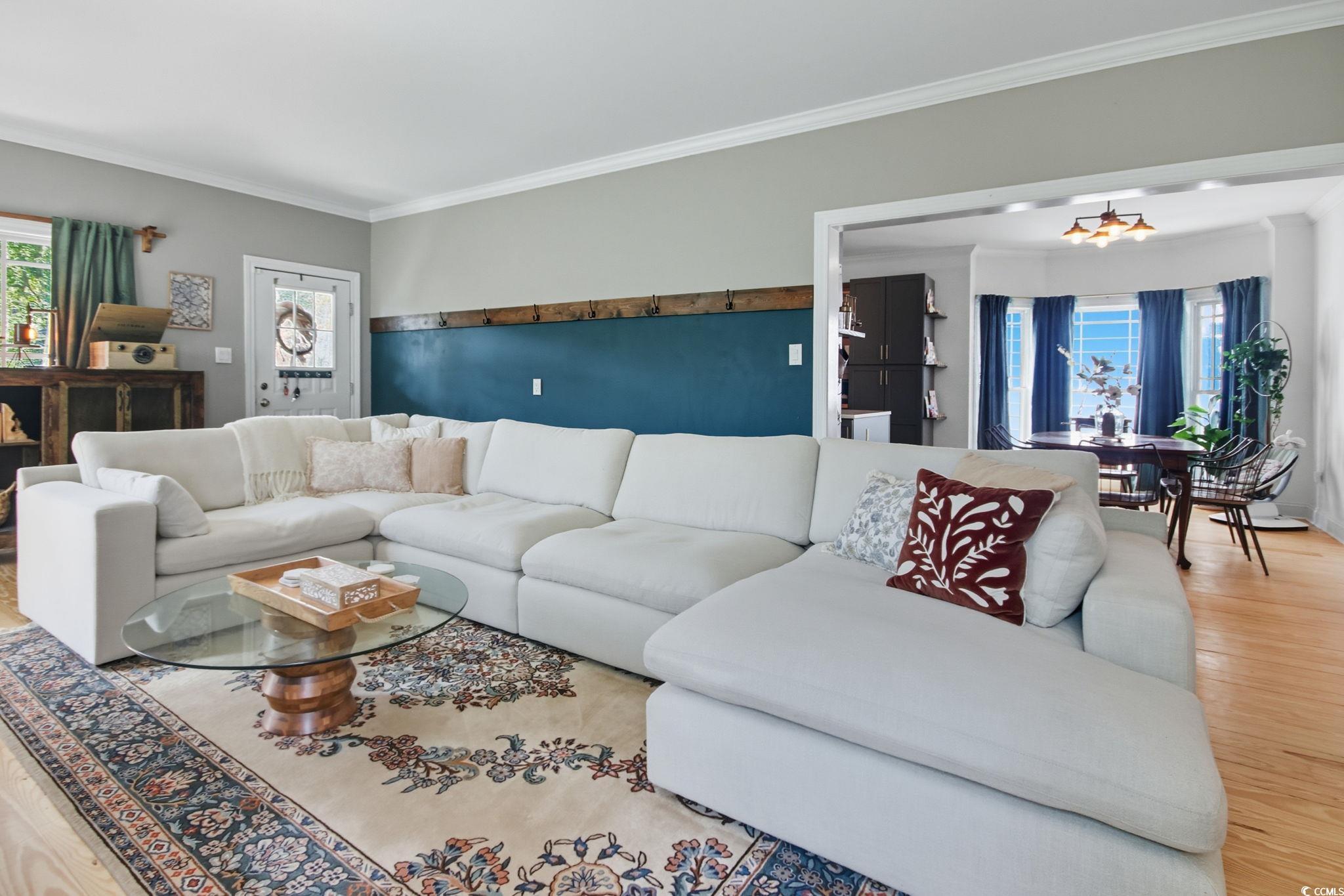 21 Craftsman Lane Georgetown, SC 29440 - Photo 7 of 39 Living room with wood finished floors, crown molding, and a chandelier