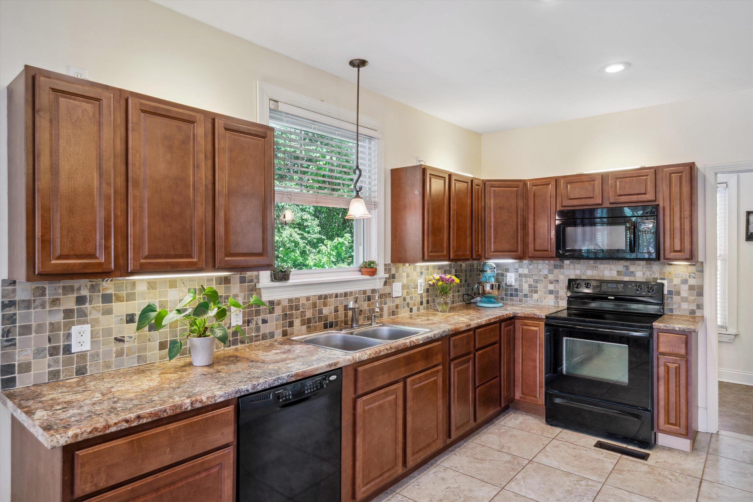 30 Blue Gray Road Piperton, TN 38017 - Photo 9 of 31 a kitchen with stainless steel appliances granite countertop a stove a sink dishwasher and a refrigerator with wooden cabinets