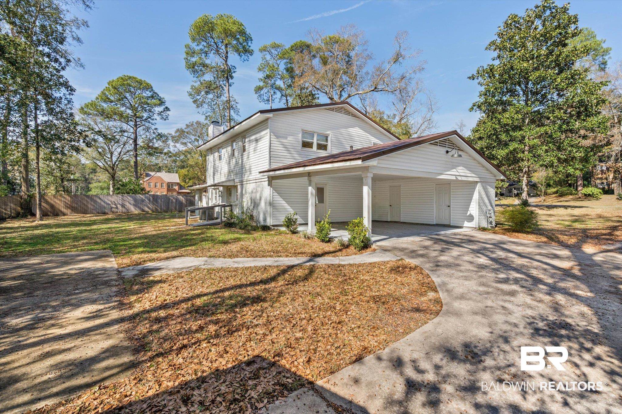 3933 Radnor Avenue Mobile, AL 36608 - Photo 28 of 36 View of home's exterior featuring metal roof, concrete driveway, an attached carport, a chimney, and covered porch