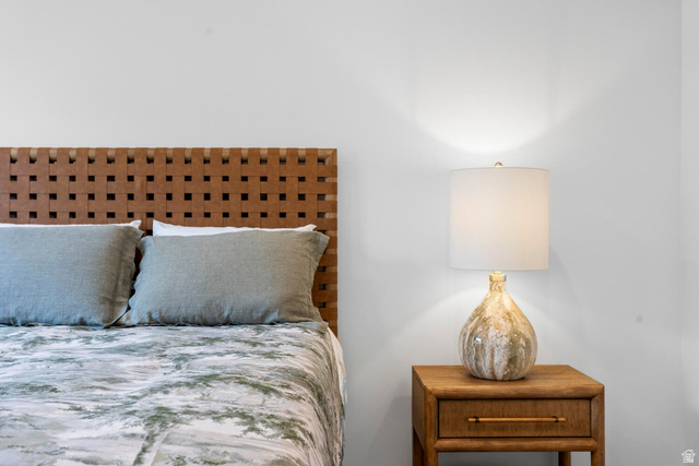 1624 South Staircase Way, Unit 4183 Washington, UT 84780 - Photo 12 of 47 Woven leather-finish headboard accentuates this bedroom space, complemented by a wood-finish nightstand and contemporary lighting fixture