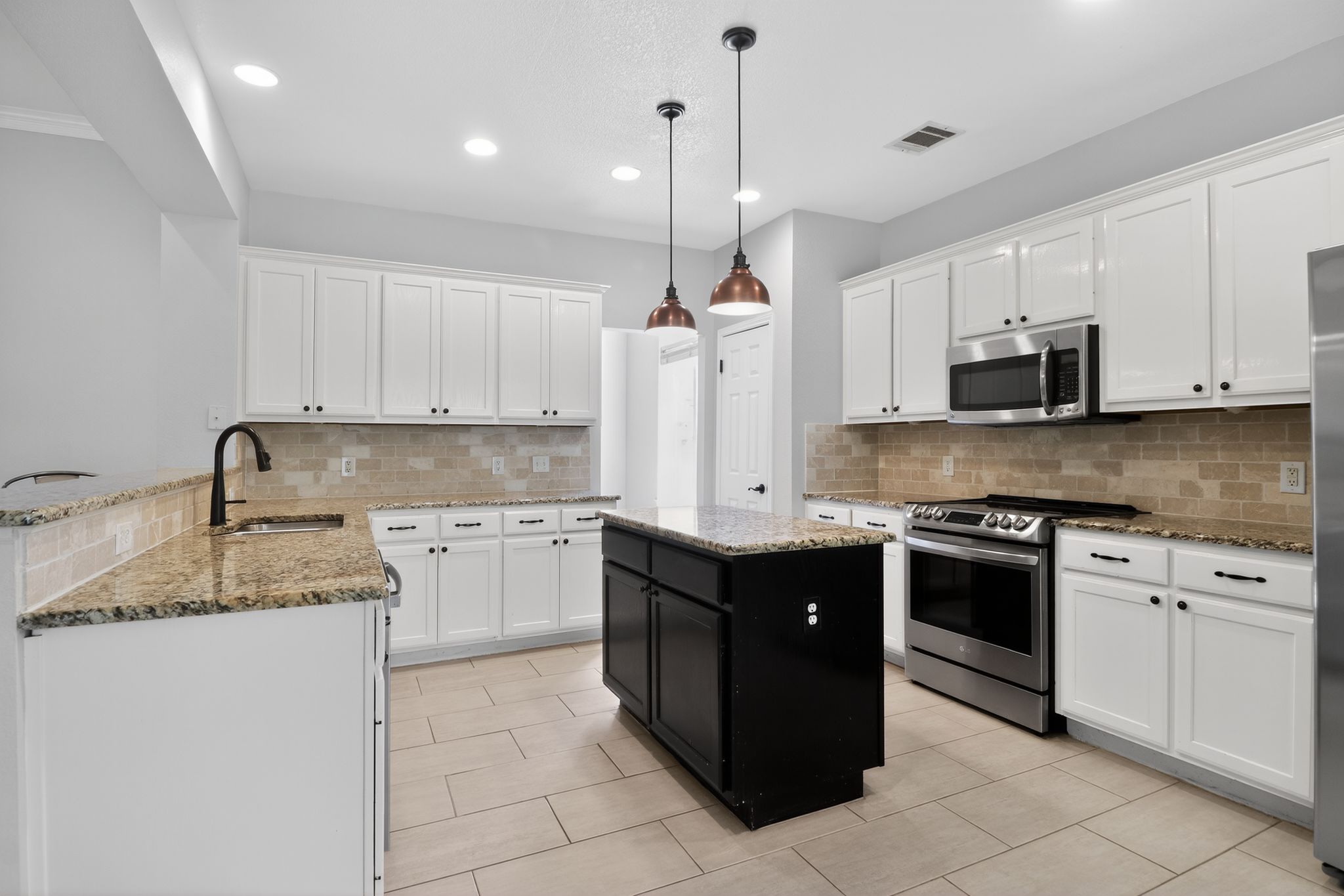 11918 Arbor Downs Road Austin, TX 78748 - Photo 14 of 29 Dual tone kitchen with stainless steel appliances, light stone countertops, pendant lighting, a center island, and a peninsula