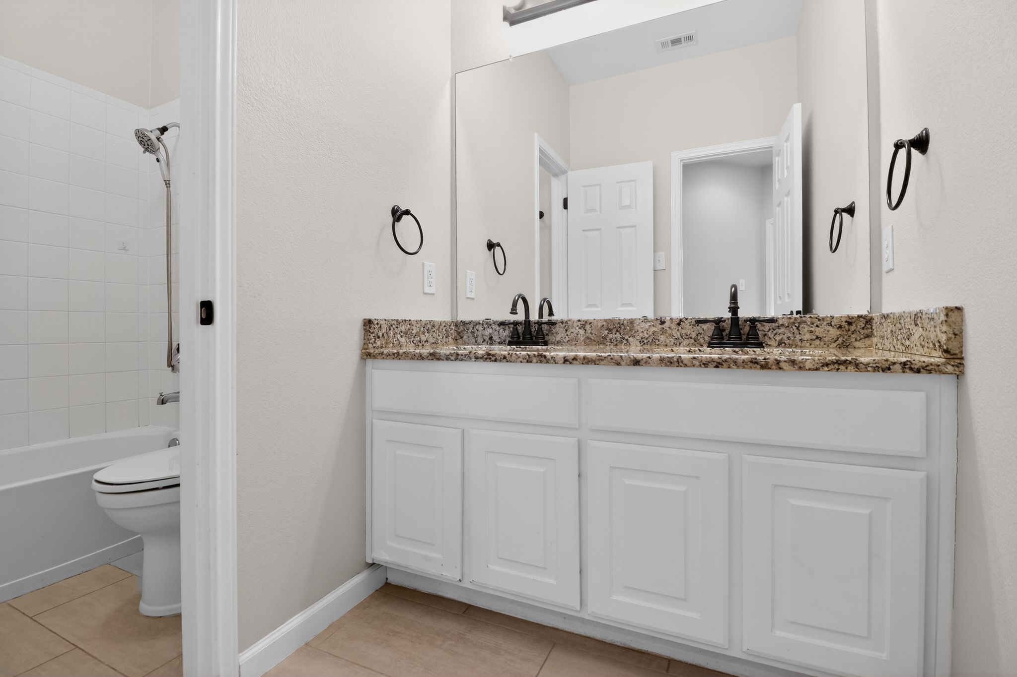 11918 Arbor Downs Road Austin, TX 78748 - Photo 22 of 29 Bathroom with double vanity, tub / shower combination, and light tile patterned floors