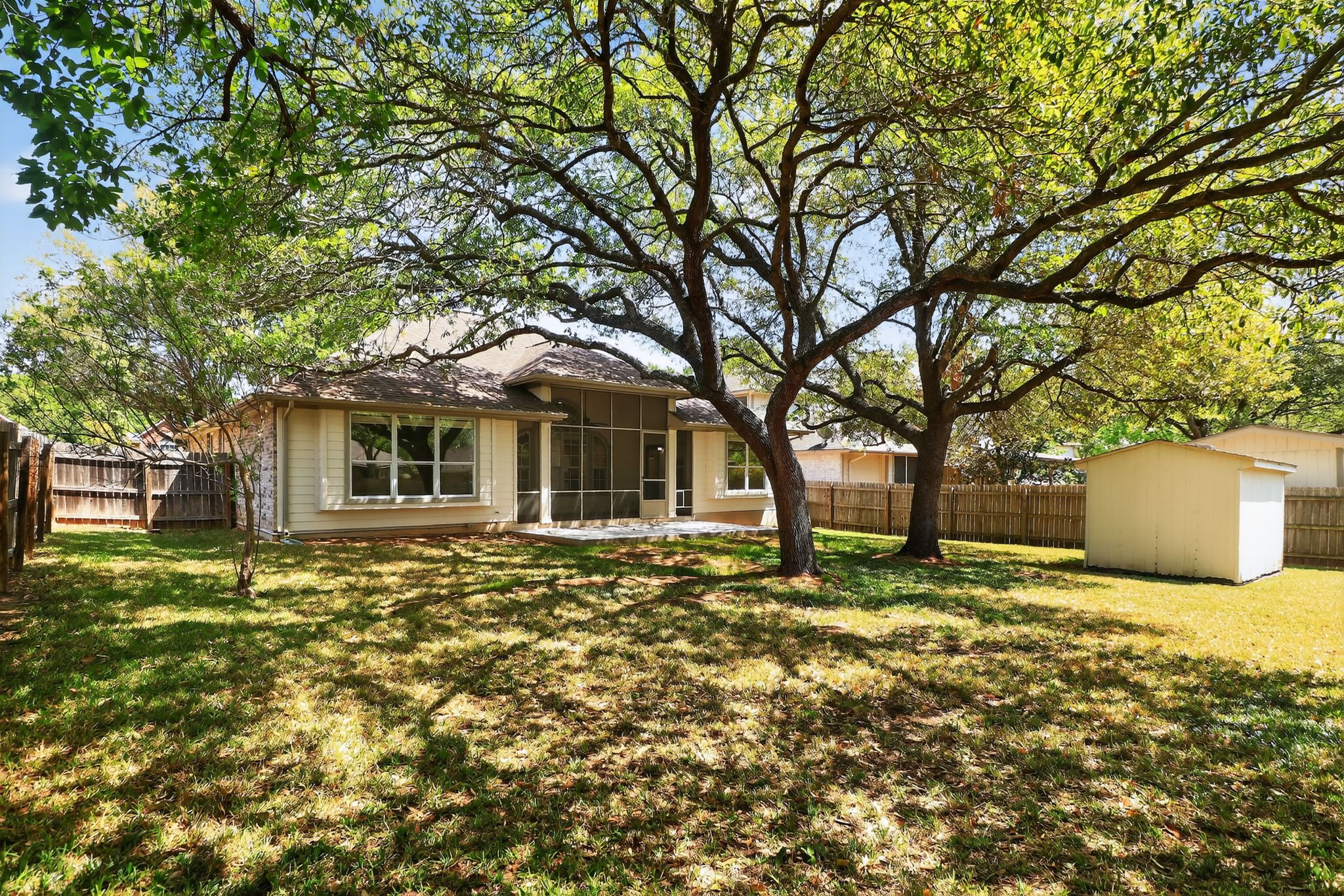 11918 Arbor Downs Road Austin, TX 78748 - Photo 29 of 29 Rear view of property featuring a sunroom, a fenced backyard, and a storage shed