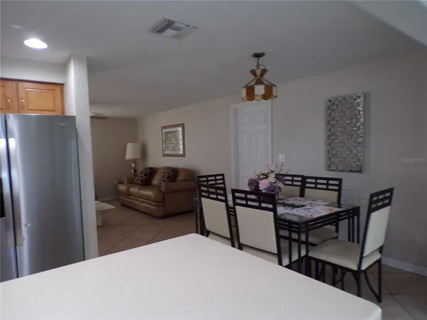 a living room with furniture and a refrigerator