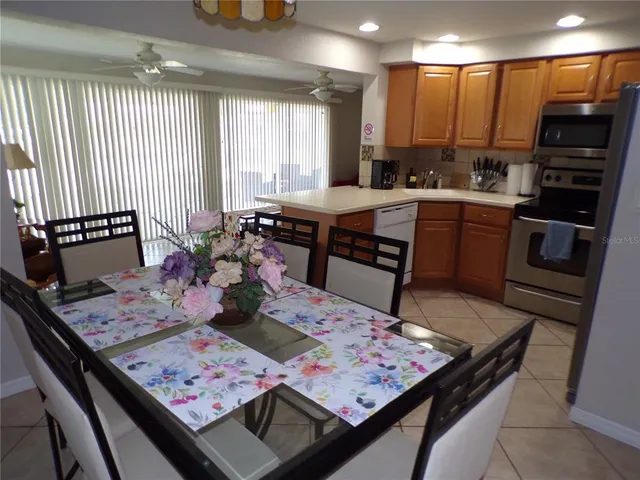 a kitchen with a stove a sink dishwasher and a dining table with garden view