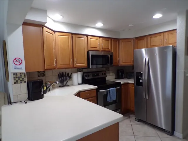 a kitchen with stainless steel appliances a refrigerator a stove a microwave a sink and dishwasher
