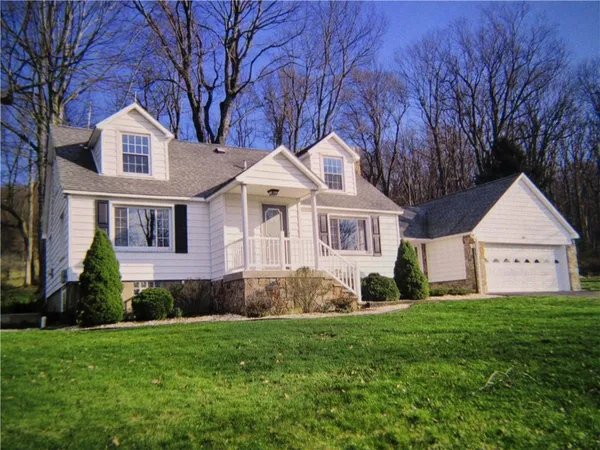 a front view of a house with a garden and yard