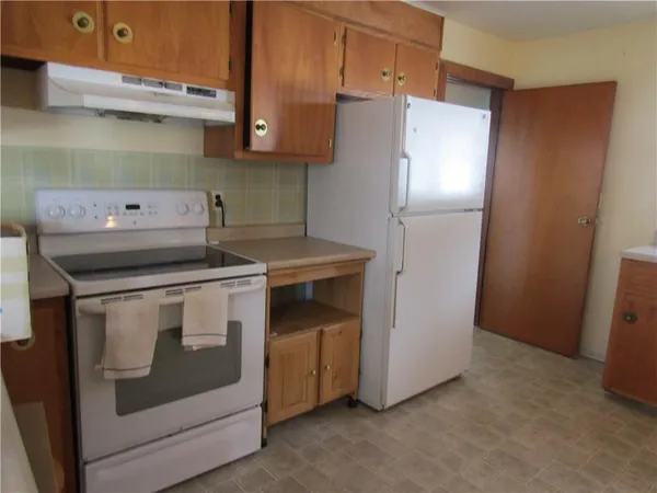 a kitchen with a stove refrigerator and cabinets
