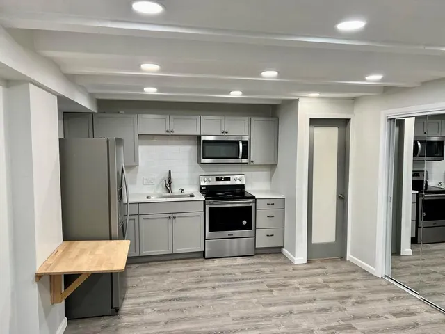 a kitchen with stainless steel appliances a stove refrigerator sink and cabinets