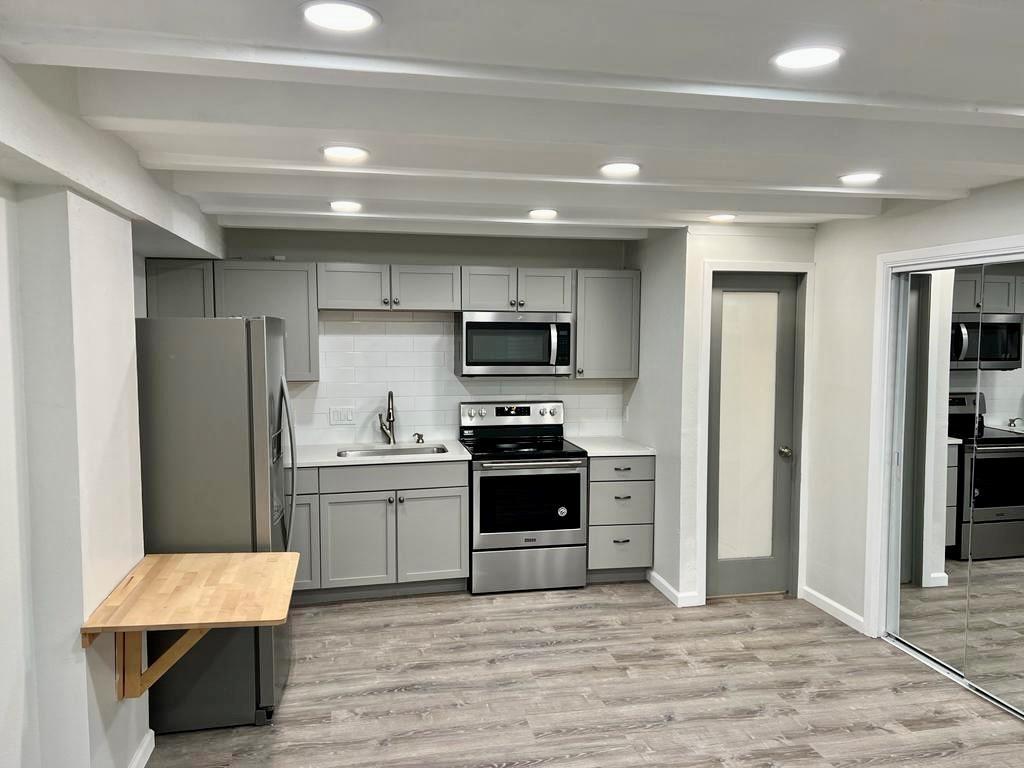 a kitchen with stainless steel appliances a stove refrigerator sink and cabinets