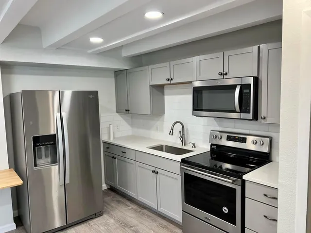 a kitchen with a sink stainless steel appliances and cabinets