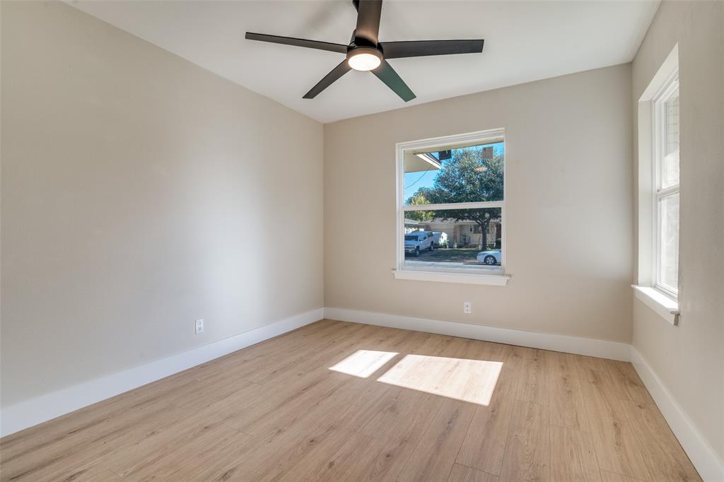 9209 Rustown Drive Dallas, TX 75228 - Photo 22 of 28 an empty room with wooden floor chandelier fan and windows