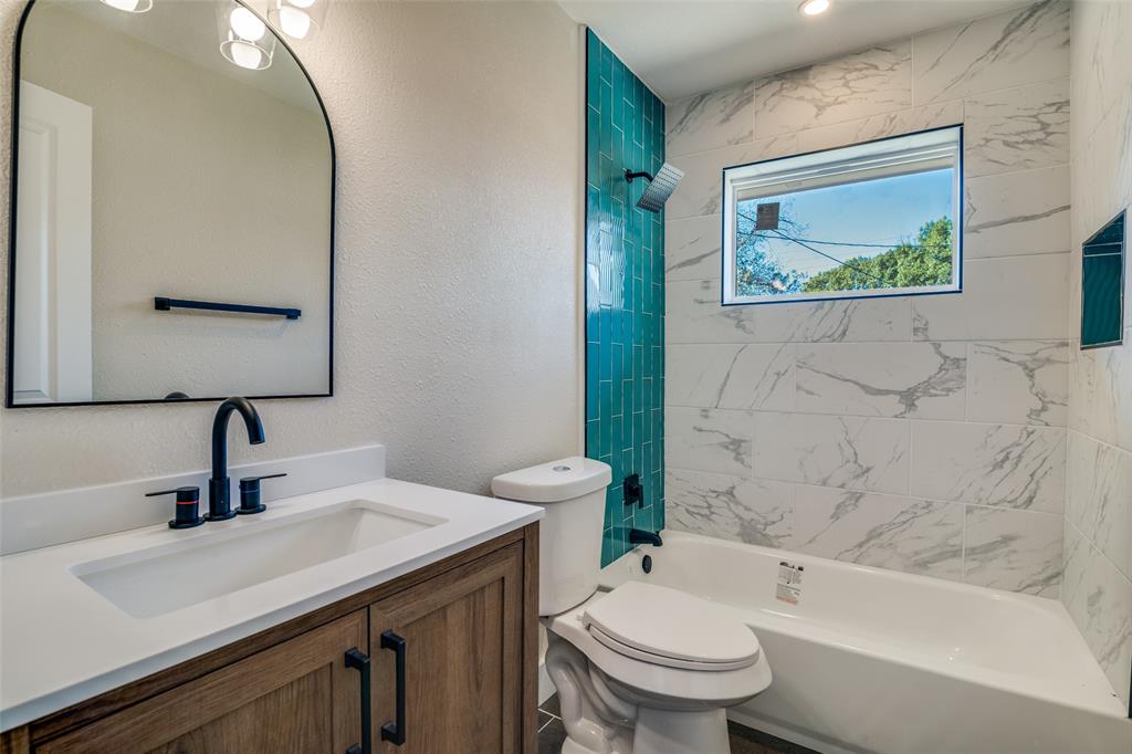 9209 Rustown Drive Dallas, TX 75228 - Photo 23 of 28 a bathroom with a toilet a sink and mirror