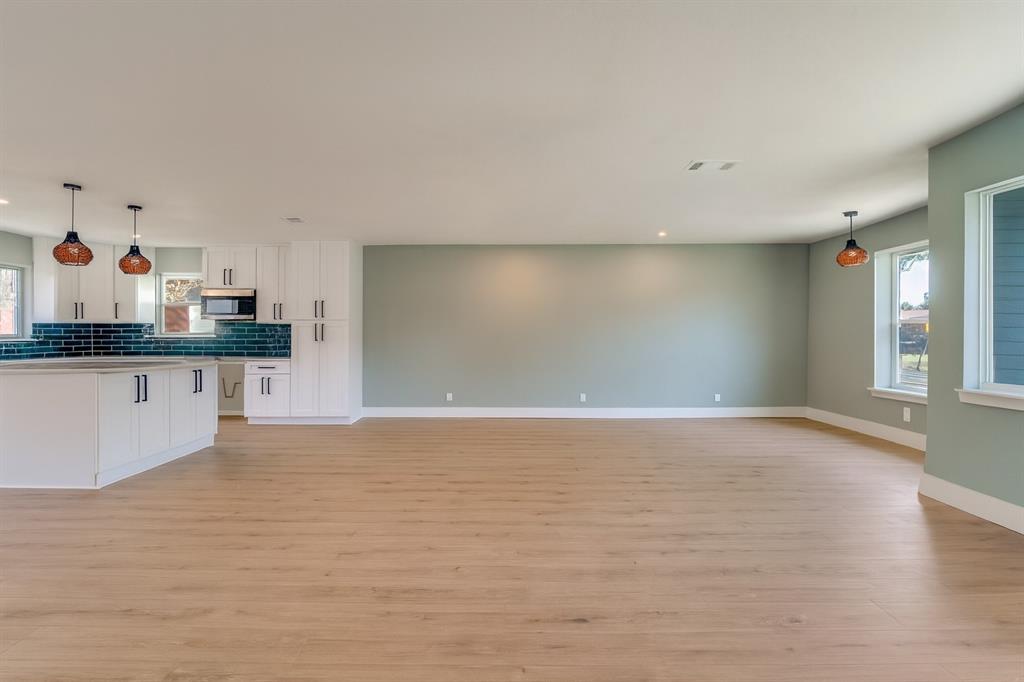 9209 Rustown Drive Dallas, TX 75228 - Photo 3 of 28 a view of a kitchen with granite countertop a sink and dishwasher a stove top oven with wooden floor