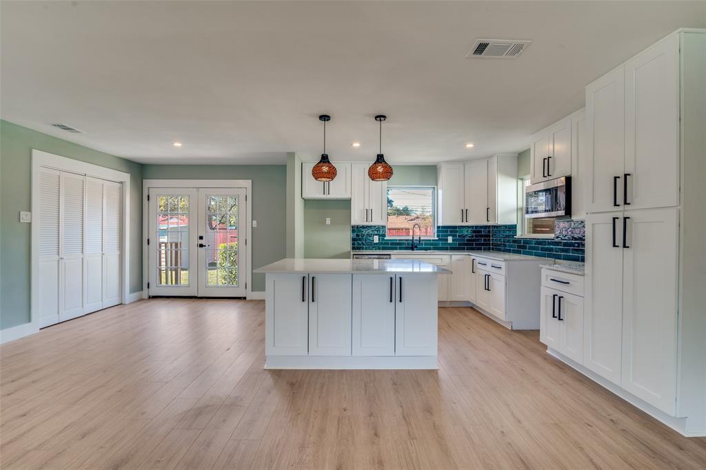 9209 Rustown Drive Dallas, TX 75228 - Photo 7 of 28 a kitchen with white cabinets and stainless steel appliances