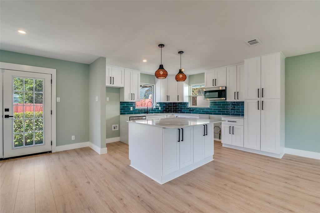 9209 Rustown Drive Dallas, TX 75228 - Photo 8 of 28 a kitchen with stainless steel appliances granite countertop a stove a sink and a refrigerator