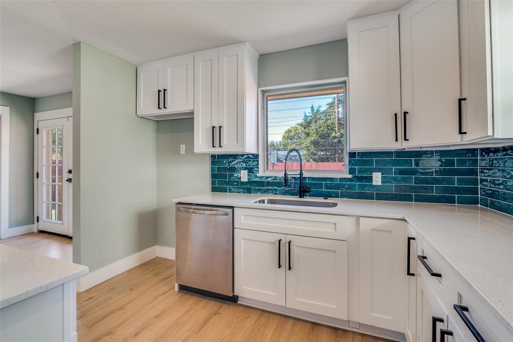 9209 Rustown Drive Dallas, TX 75228 - Photo 9 of 28 a kitchen with stainless steel appliances white cabinets and a window