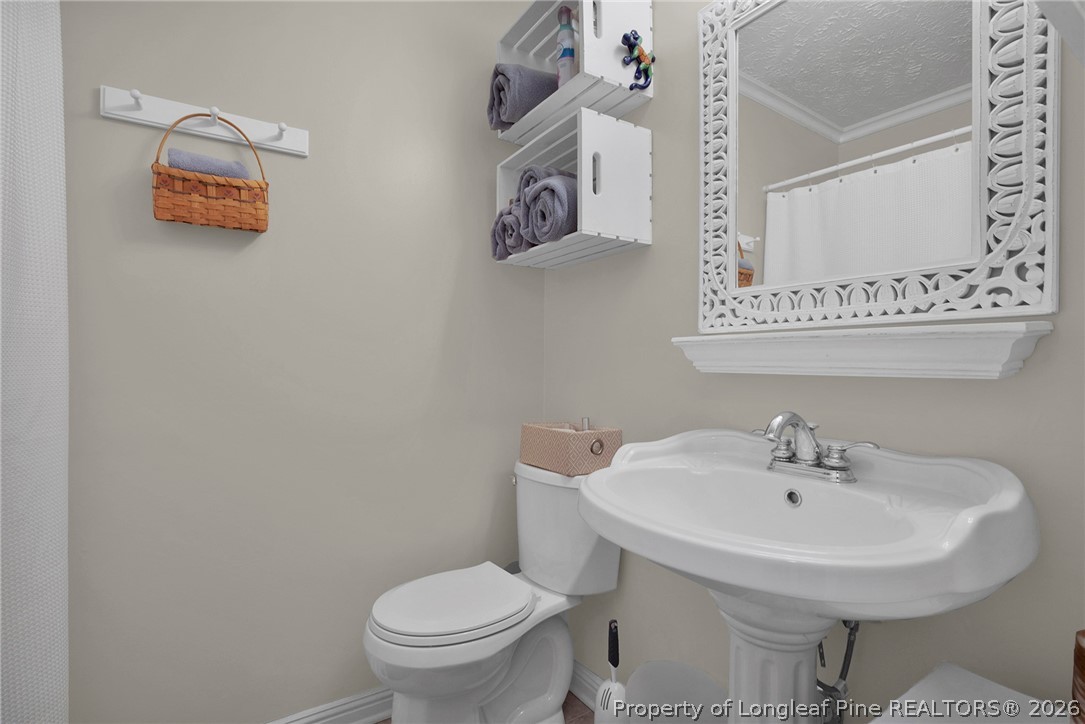 4425 Bishamon Street Hope Mills, NC 28348 - Photo 22 of 39 a bathroom with a sink a toilet and a mirror