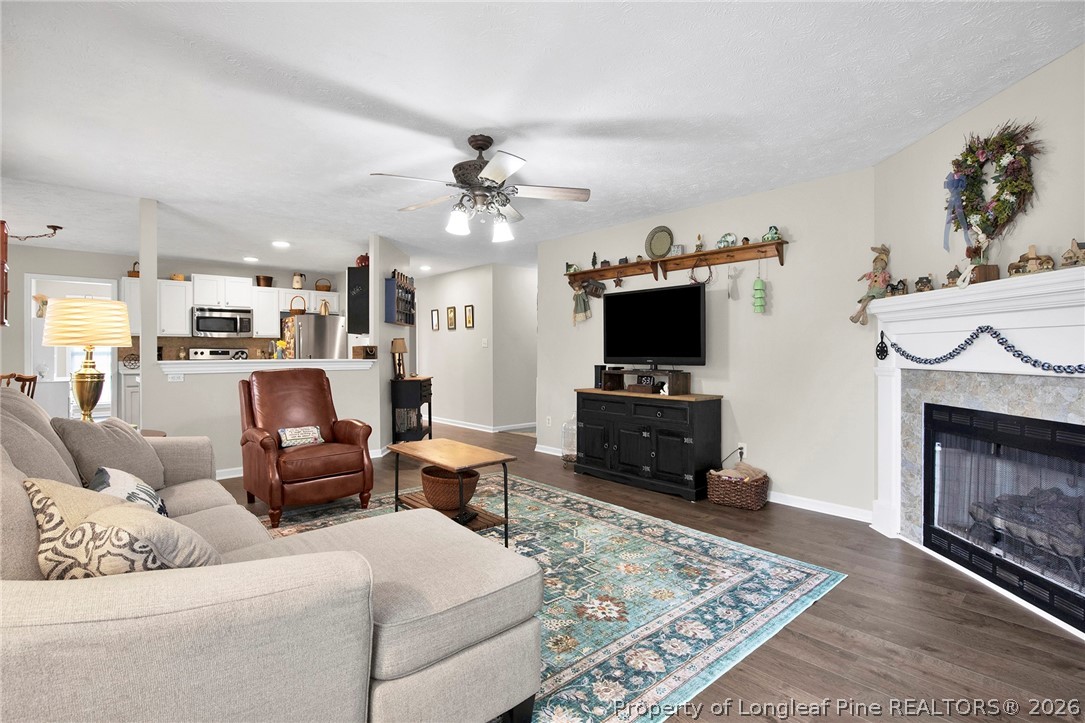 4425 Bishamon Street Hope Mills, NC 28348 - Photo 8 of 39 a living room with furniture a fireplace and a flat screen tv
